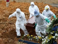 Coveiros vestidos com roupas de proteção para enterrar mais uma vítima de coronavírus em Manaus (Foto: Bruno Kelly/ Reuters)